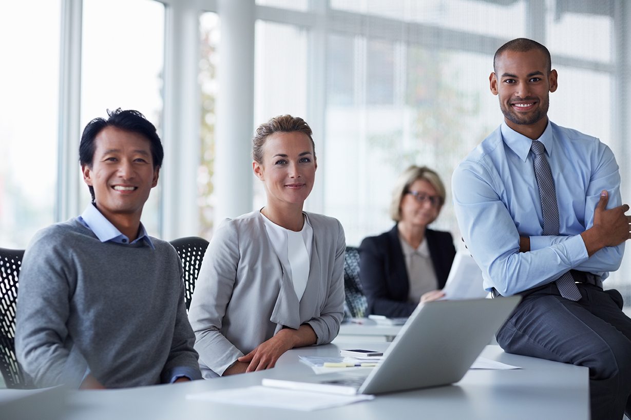 Portrait of confident businesspeople at office desk