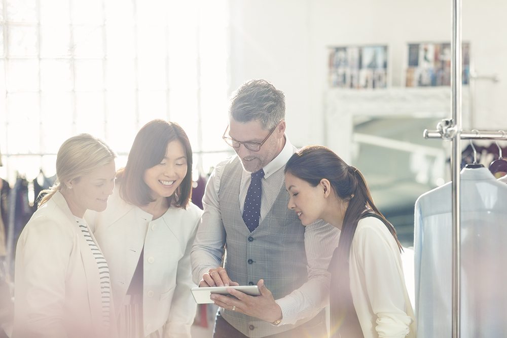 Fashion designers sharing digital tablet in office. First Independent Bank is ready to help you purchase, refinance or improve your real estate property for your business or investment portfolio.