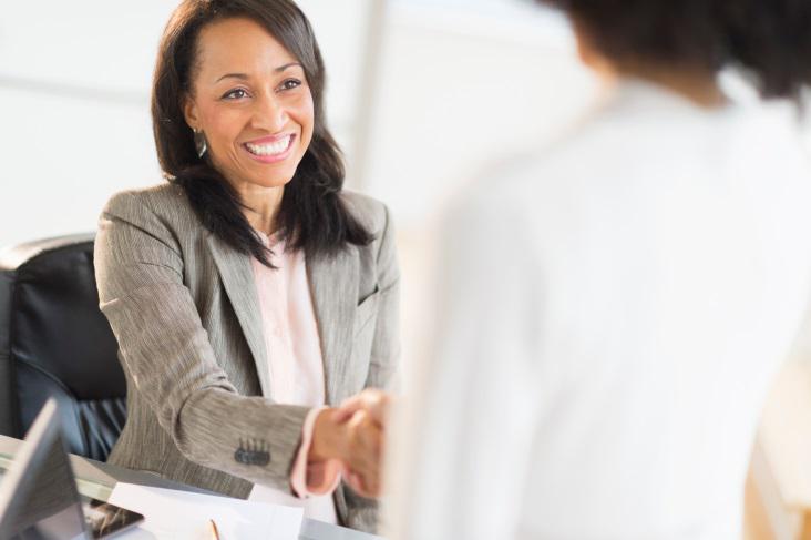 Business woman at a desk shaking hands with a colleague. Click to learn more about how Bank of Nevada is helping attorneys and law firms with their distinct banking needs.