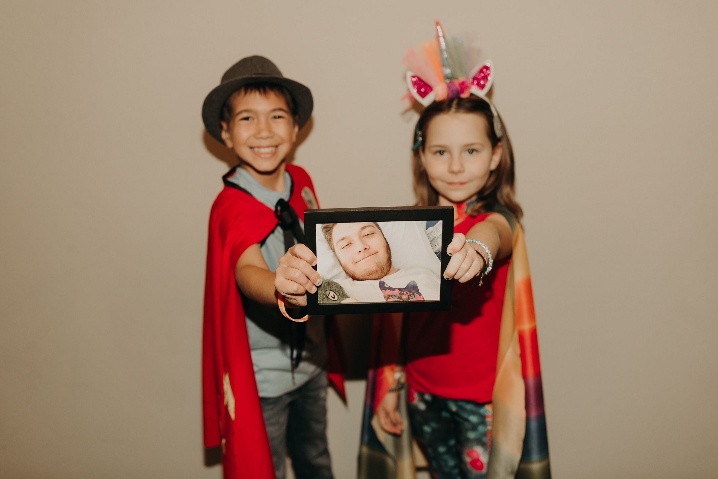 Candlelighters Superhero Ambassadors James Kish and Alexa Garin holding photo of Angel Ambassador Cooper Ricciardi - 0156 sm
